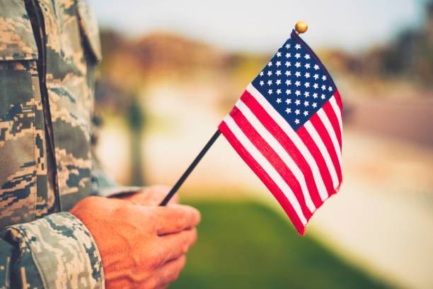 Veteran's Day in America. Soldier with American Flag Veteran's Day in America. Soldier with American Flag memorial day stock pictures, royalty-free photos & images