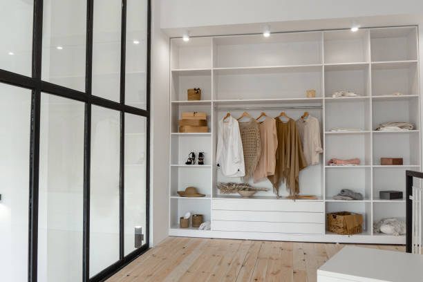 Vew on open space minimalistic scandinavian white wood walk in closet with wardrobe in neutral beige colors Vew on open space minimalistic scandinavian white wood walk in closet with wardrobe in neutral beige colors closet stock pictures, royalty-free photos & images