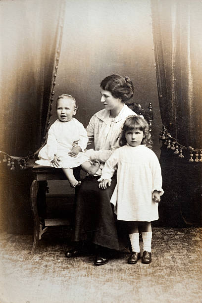 Victorian Family A young mother poses with her two children for a family portrait. Circa 1910. Some dust and scratches which convey age and condition of original image.See my vintage images lightbox for more... victorian style photos stock pictures, royalty-free photos & images