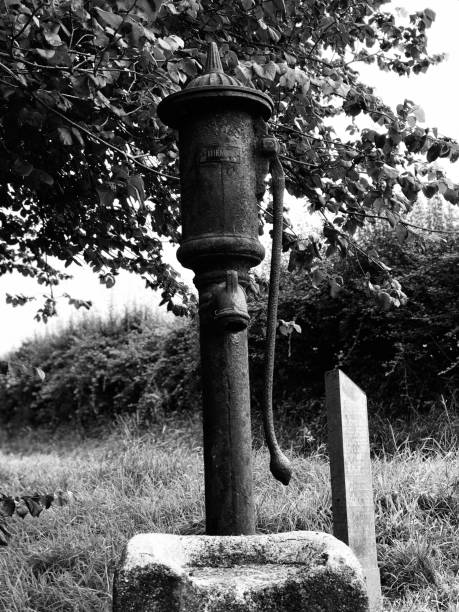 Victorian village pump Victorian village pump, now obsolete, but the well remains full of water. The parish of Feock, Cornwall. thomas wells stock pictures, royalty-free photos & images