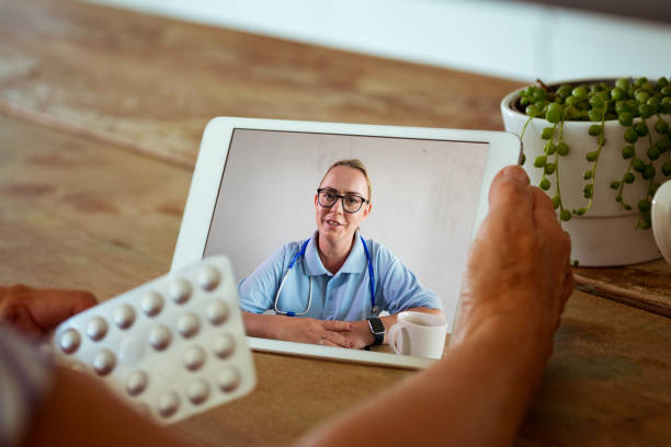 Video call with female doctor Telemedicine concept. Senior woman using digital tablet and having video call with nurse. Close up of screen and pills. nurse talking to camera stock pictures, royalty-free photos & images