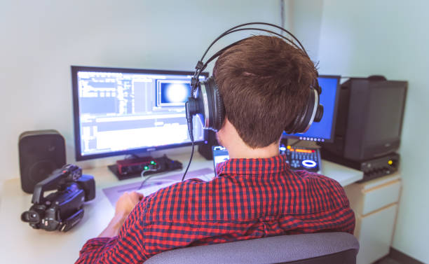 Video editor in the cutting room, close up, monitors in blurry background stock photo