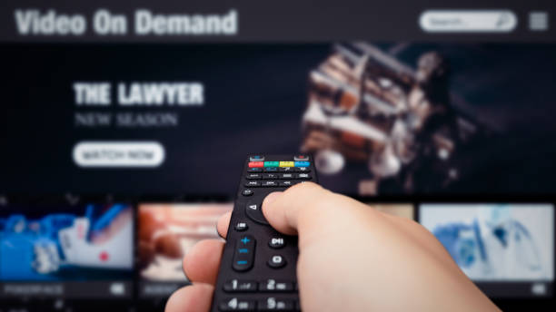 Video on demand, TV streaming, multimedia Video on demand, TV streaming, multimedia. Hand holding remote control streaming service stock pictures, royalty-free photos & images