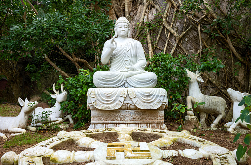 Danang, Vietnam - November 21, 2019: The statue of Buddha with deer in the gardens of the Marble Mountain