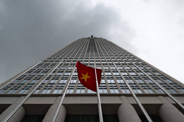 Vietnamese flag in front of corporate skyscraper in the Ho Chi Minh city stock photo