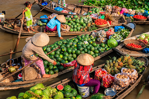 Vietnamese women selling and buying fruits on floating market, Mekong River Delta, Vietnam