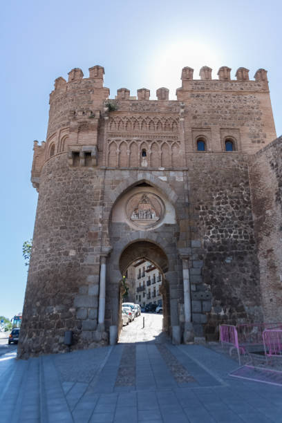 View at the Medieval Sun gate, 14th century fortress gate monument, with an arched entryway & picturesque city views, in Toledo downtown stock photo