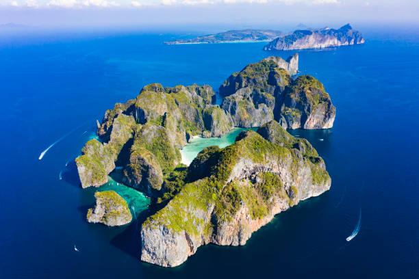 view from above, stunning aerial view of koh phi phi lee with the beautiful beach of maya bay bathed by a turquoise and clear water. amazing ridges of limestone mountains surround this magnificent island of thailand. - maya bay imagens e fotografias de stock