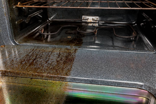 View inside electric oven with one half shiny clean and half filthy covered in burnt grease and food on glass and door. Housecleaning concept and comparison closeup, no people oven stock pictures, royalty-free photos & images