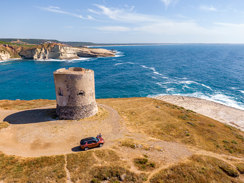 View of a beautiful bay along the coast with ruined tower in summertime, Sardinia, Italy.