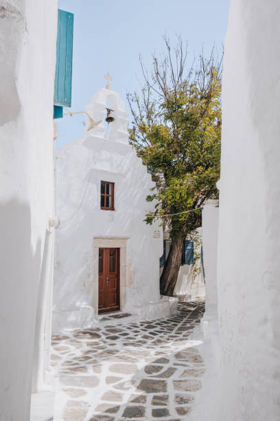 View of a chapel from a narrow street in Hora (Mykonos Town), Mykonos, Greece. stock photo
