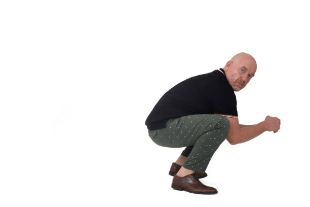 view of a man squatting on white background stock photo
