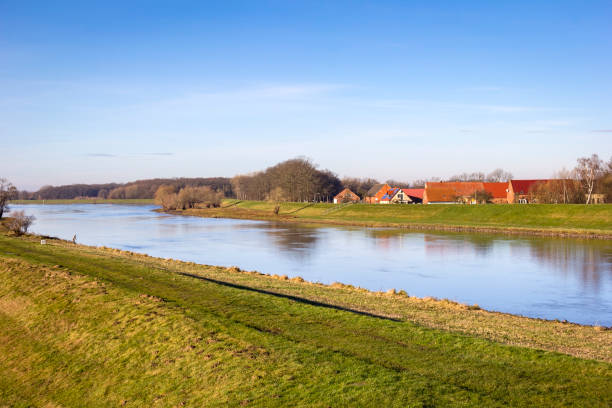 View of a small village directly behind the dyke of the river Elbe View of a small village directly behind the dyke of the river Elbe. The dike is the most important protection against flooding. The houses show the typical north German brick construction. elbe river stock pictures, royalty-free photos & images
