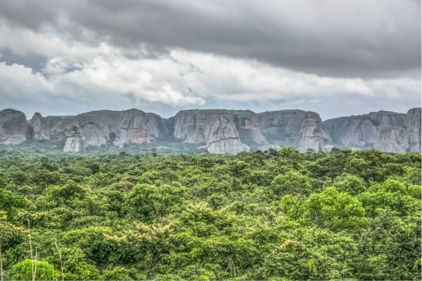 View of a tropical landscape, with forest and mountains Pungo Andongo, Pedras Negras , black stones, huge geologic rock elements, cloudy sky as background stock photo