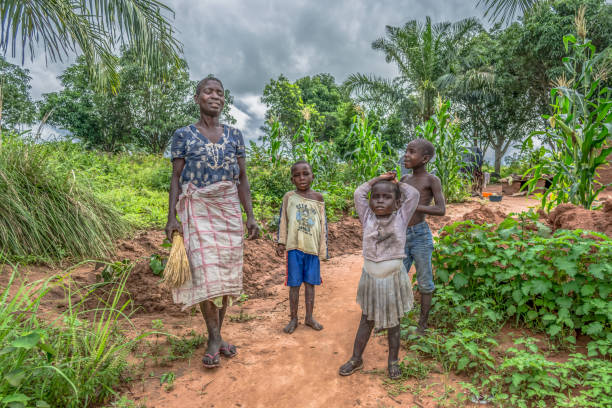 View of an Angolan family, mother with her three children, in front of her small farmland stock photo