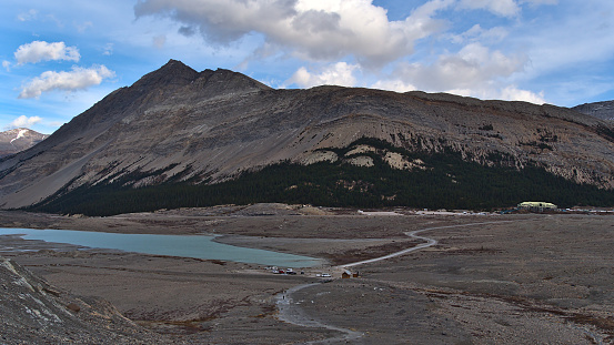 View of Athabasca River Valley in Jasper National Park, Alberta, Canada with lake, rocky glacial moraine, car park and visitor center at Icefields Parkway in the Rocky Mountains in autumn season.