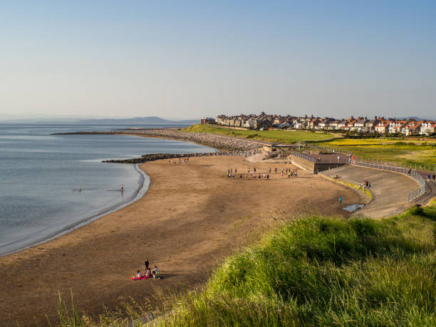 View of beach at Heysham on summer evening with people enjoying sunshine View of beach at Heysham on summer evening with people enjoying sunshine lancashire stock pictures, royalty-free photos & images