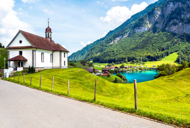 View of Burglen Village landscape by Lake Lungern or Lungerersee in Obwalden, Switzerland View of Burglen Village landscape by Lake Lungern or Lungerersee in Obwalden, Switzerland. lungern village switzerland lake stock pictures, royalty-free photos & images