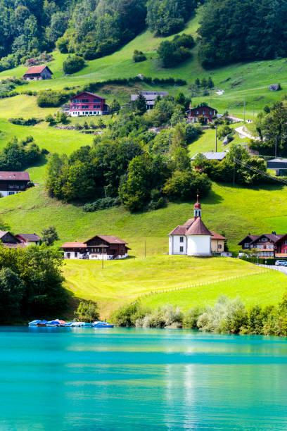 View of Burglen Village landscape by Lake Lungern or Lungerersee in Obwalden, Switzerland View of Burglen Village landscape by Lake Lungern or Lungerersee in Obwalden, Switzerland. lungern village switzerland lake stock pictures, royalty-free photos & images