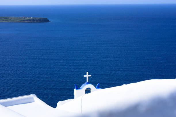 View of church cross in the background of blue Aegean Sea stock photo