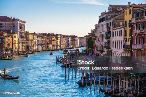 istock View of facades of picturesque old buildings on the Grand Canal, gondolas and boats in Venice. Sunny summer day with blue sky 1389578634
