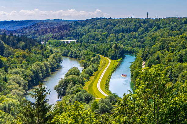 View of Isar River and Canal Photograph taken on the 30th November 2018 by Desmond Stagg from the top tower of Burg Grunwald. Burg Grunwald is located in Grunwald which is a suburb in the south of Munich, Bavaria, Germany.
On the left, inline with the first third of the image the river Isar is visible. Lined up with the second third, the Isar Canal is visible. 
A raft full of passengers, who are unrecognisable is floating with the current along the water. river isar stock pictures, royalty-free photos & images