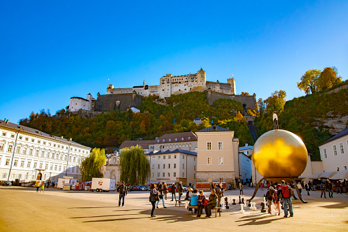 Kapitelplatz square with a sculpture of a man on a golden sphere in Salzburg City. Taken in Salzburg, Austria, October 20, 2016