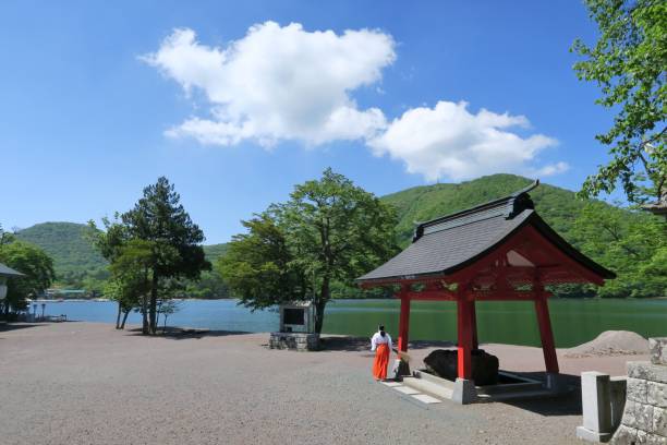 View of Lake Onuma and a Miko (shrine meiden) from Akagi shrine main building in Akagi, Gunma, Japan. June 9, 2021. stock photo