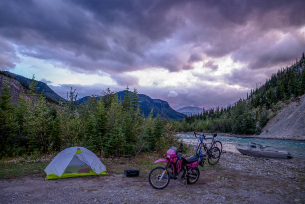 blick auf motorrad mit rennrad außerhalb des campingplatzes am morgen - motorrad fluss stock-fotos und bilder
