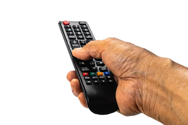 View of old man hand press the button on television remote control to select the television program on white background. stock photo