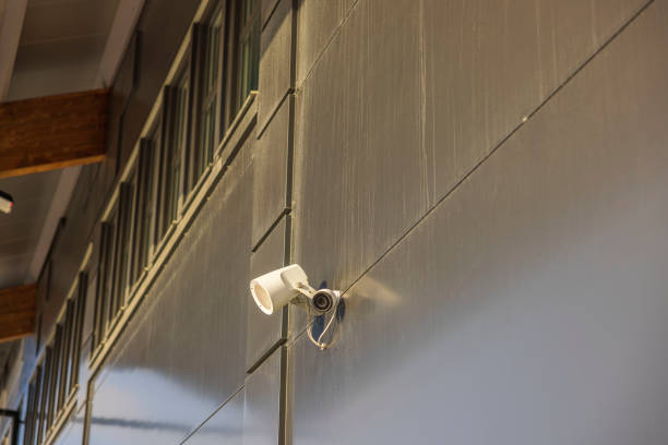 View of outdoor speaker and public safety surveillance camera on gray wall. Sweden. stock photo