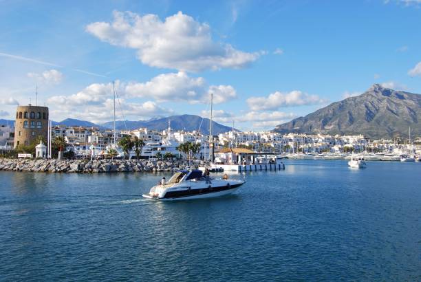 View of Puerto Banus harbour, Marbella, Spain. Harbour entrance with the watchtower to the left and La Concha mountain to the right, Puerto Banus, Marbella, Spain. marbella stock pictures, royalty-free photos & images
