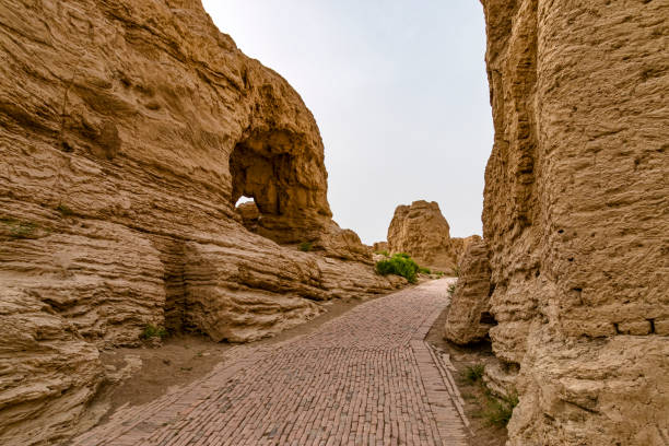 View of Road Through Jiaohe Ruines, Xinjiang, China. Jiaohe or Yarkhoto is a ruined city in the Yarnaz Valley, 10 km west of the city of Turpan in Xinjiang Uyghur Autonomous Region, China. It was the capital of the Jushi Kingdom. It is a natural fortress on the Silk Road located atop a steep cliff between two deep river valleys. silk road stock pictures, royalty-free photos & images