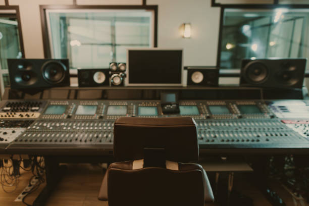 view of sound producing equipment at recording studio with armchair on foreground view of sound producing equipment at recording studio with armchair on foreground recording studio stock pictures, royalty-free photos & images
