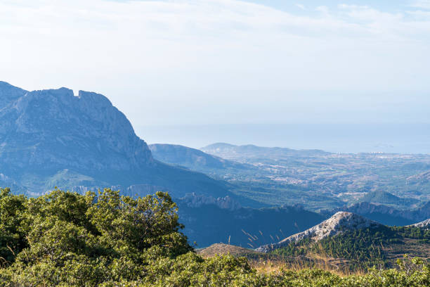 View of the Alicante coast from the top of the Aitana mountain with "Puig camapana" peak in the left, Confrides, Alicante, Spain. stock photo