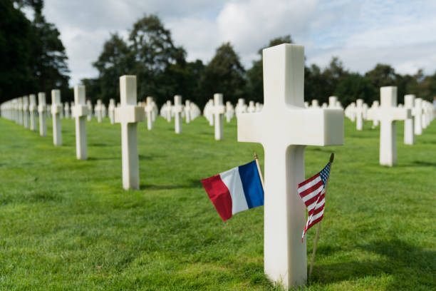 вид на американское кладбище на пляже омаха в нормандии с французскими и американскими флагами - colleville стоковые фото и изображения