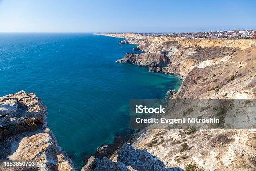 istock View of the Black Sea coast in Crimea, Cape Fiolent in Sevastopol. Panoramic seascape, calm azure sea, clouds and bright sky. 1353850703