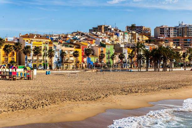 View of the colorful houses of the town of Villajoyosa from its beach at sunrise. stock photo