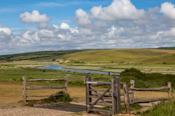 A View of the Cuckmere River in Sussex Looking out over the Cuckmere River in Sussex with a cattle grid and gate in the foreground cattle grid stock pictures, royalty-free photos & images