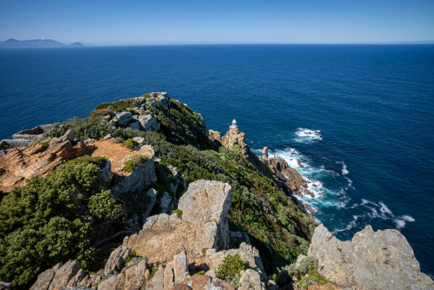 A view of the ocean and the Cape Point lighthouse on top of Dias Point, Western Cape. stock photo