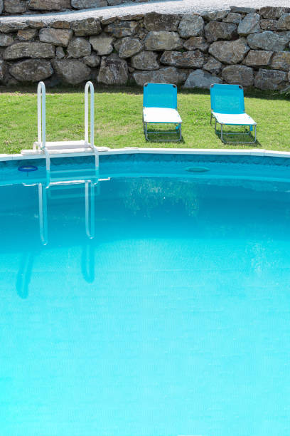 blick auf den pool mit türkisfarbener wassergrüner rasenwand aus steinen und sonnenliegen. konzepturlaub, landschaftsgestaltung, hotel, wasserpark. - pool rund stock-fotos und bilder