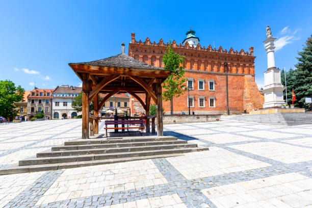 View on market with Sandomierz gothic Town Hall, old wooden well and 18th century statue of the Mother of God, Sandomierz, Poland stock photo