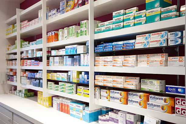 view on shelves in the sales room of a pharmacy - pijnstiller stockfoto's en -beelden