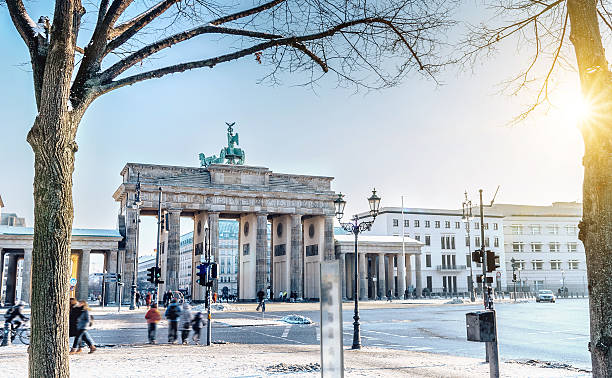 view on winterly berlin brandenburger tor in morning sun - berlin snow stockfoto's en -beelden
