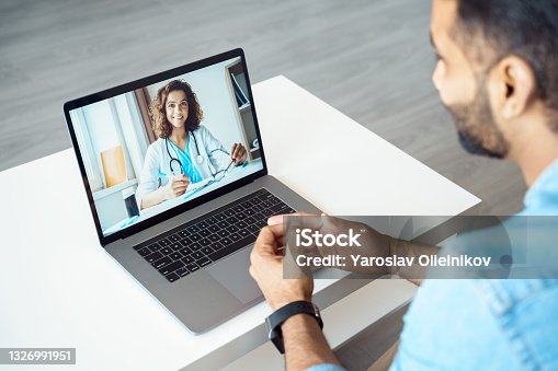 istock View over client shoulder sit at desk receive medical consultation online 1326991951