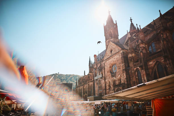 посмотреть мимо открытого летнего фруктового рынка в древний собор - freiburg стоковые фото и изображения