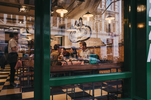 View through the window of people inside a restaurant in Covent Garden, London, UK. stock photo