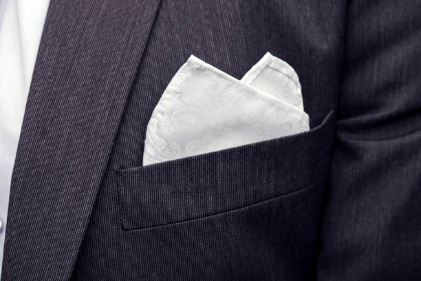 View to the male coat pocket with a fixed white square. Men's suit accessories. Wedding male guest's attire. Male wedding style. Formal dinner outfit for men. Elements of suit. Pocket square folding. View to the male coat pocket with a fixed white square. Men's suit accessories. Wedding male guest's attire. Male wedding style. Formal dinner outfit for men. Elements of a suit. Pocket square folding handkerchief stock pictures, royalty-free photos & images