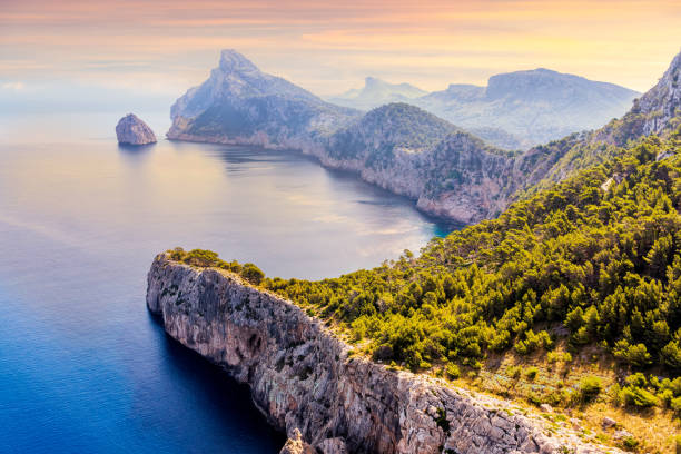 Viewpoint at the Mirador Es Colomer overseeing Formentor peninsula, beautiful sunset, Mallorca View from the Mirador Es Colomer towards the island Colomer and the mountain range on Formentor peninsula, beautiful sunset, Mallorca, Spain headland stock pictures, royalty-free photos & images