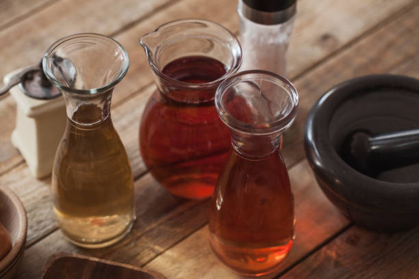 Vinegar in glass at wood table, close-up stock photo